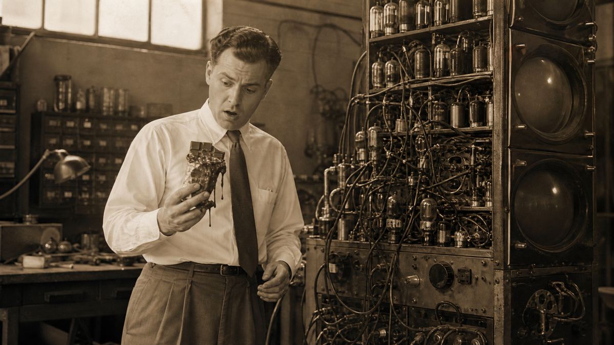 Ilustração: Percy Spencer com a barra de chocolate derretida, num laboratório de radar dos anos 1940